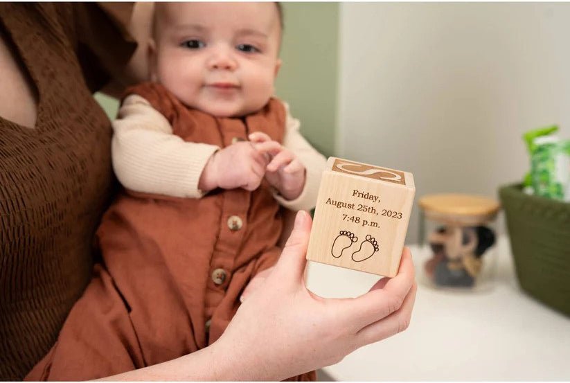 mom holding baby and wooden baby block