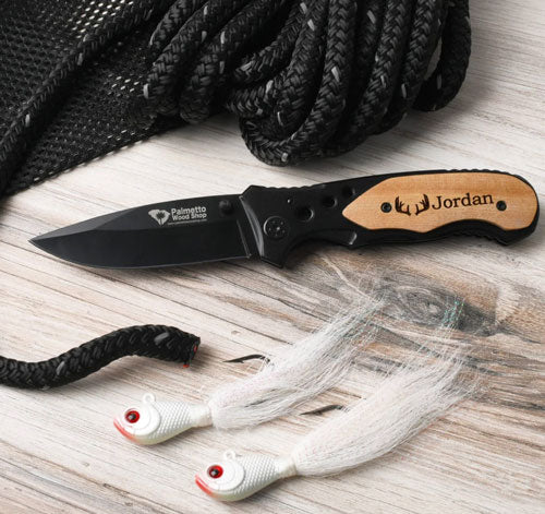 black pocket knife sitting by fishing lures