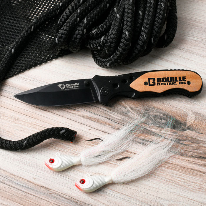 engraved pocket knife next to a rope and fishing lures